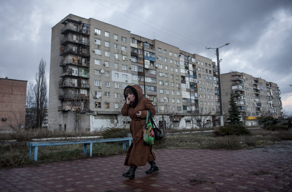 Una dona passa per davant d’un dels blocs d’habitatge bombardejats a la ciutat de Pervomaisk, a la regió de Lugansk.